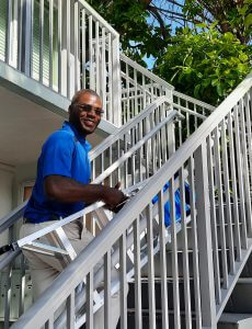 exterior painting guy walking a ladder up steps