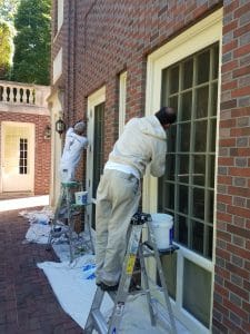 House painters in Houston doing detailed painting on the brick home.detailed prep work on home