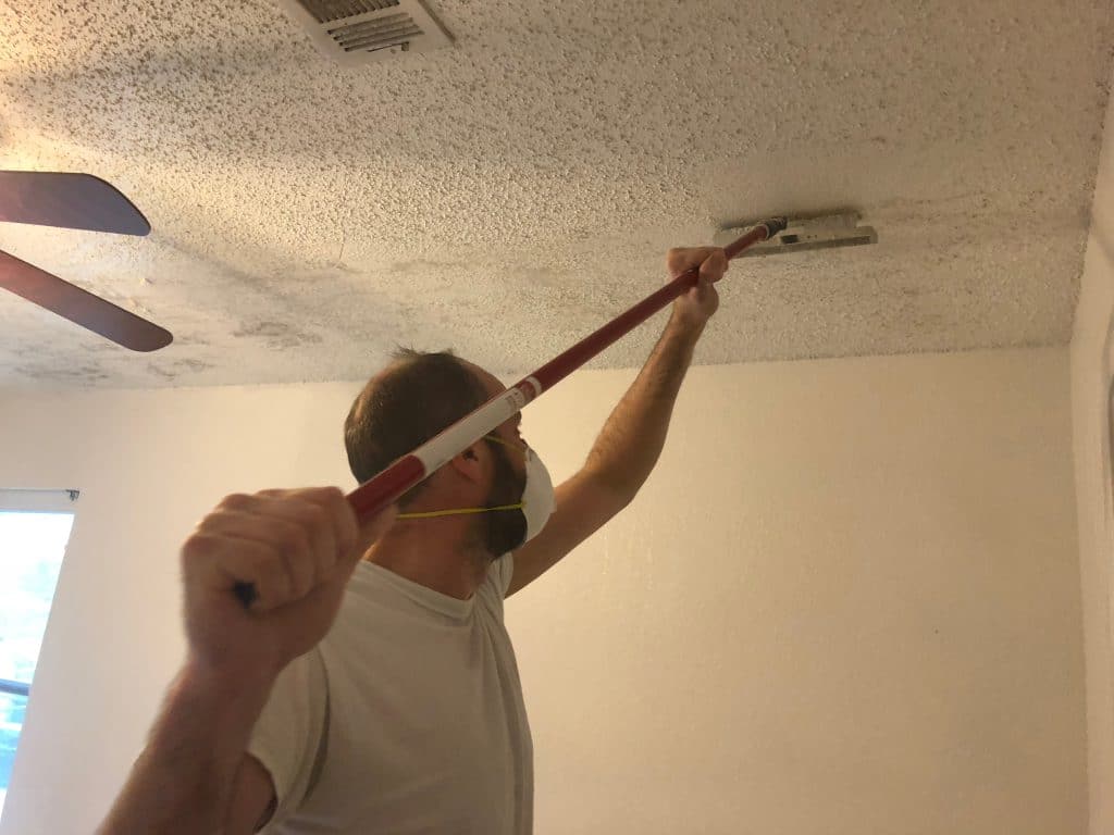 Painter removing a textured ceiling