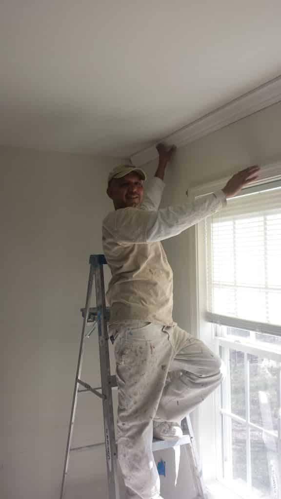 Painter installing crown molding