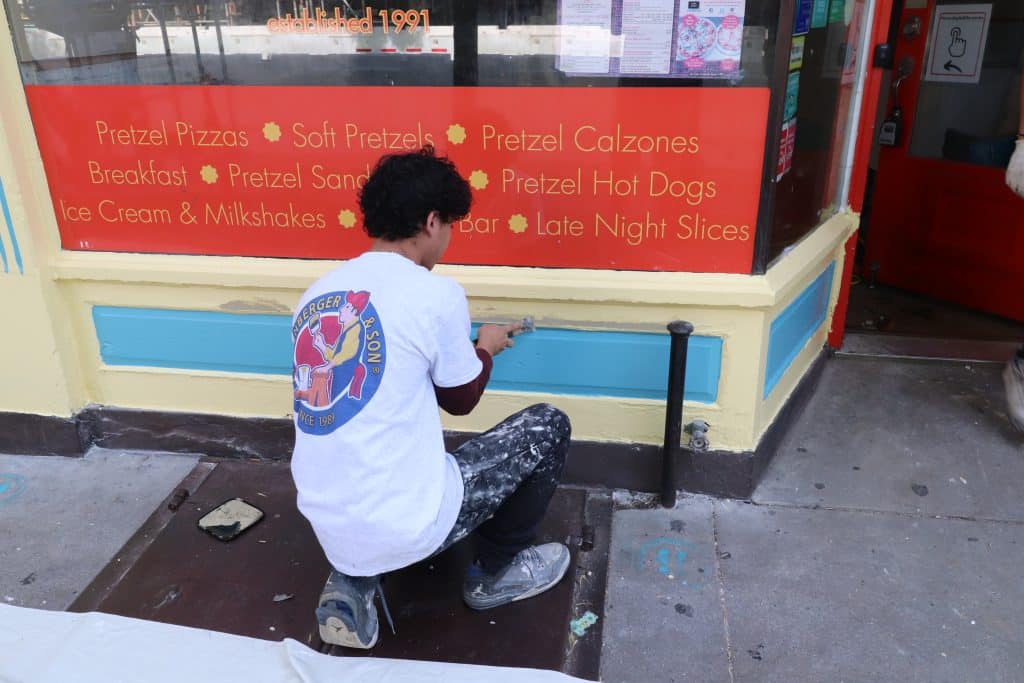 man patching historic store front.