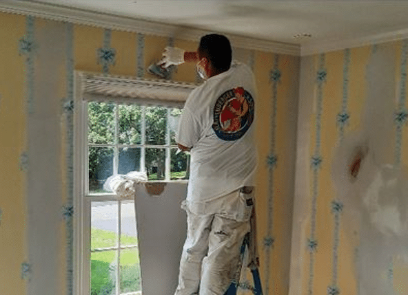 Painting company in Atlanta spackling over wallpaper.