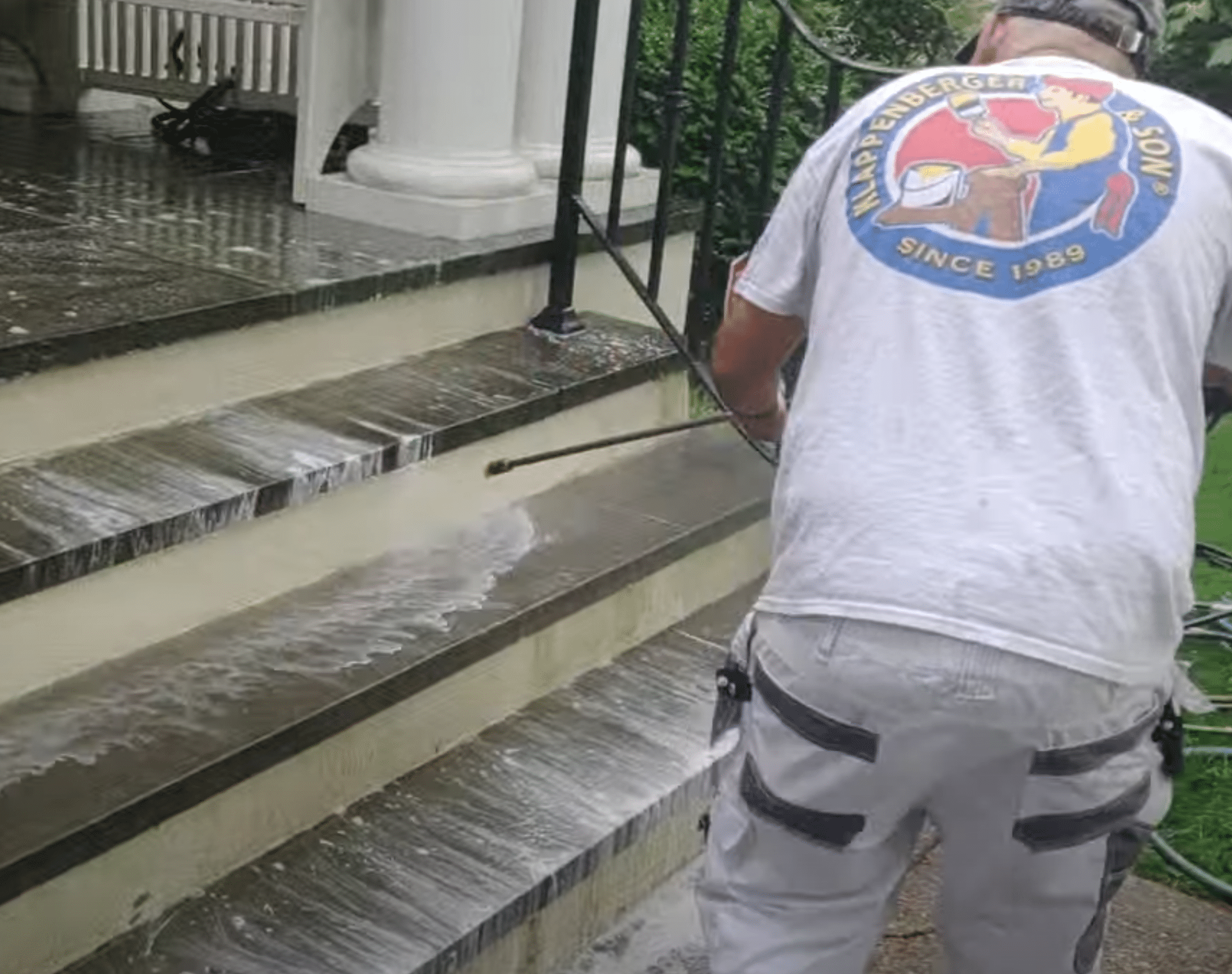 Painting company in Atlanta power washing front cement steps.