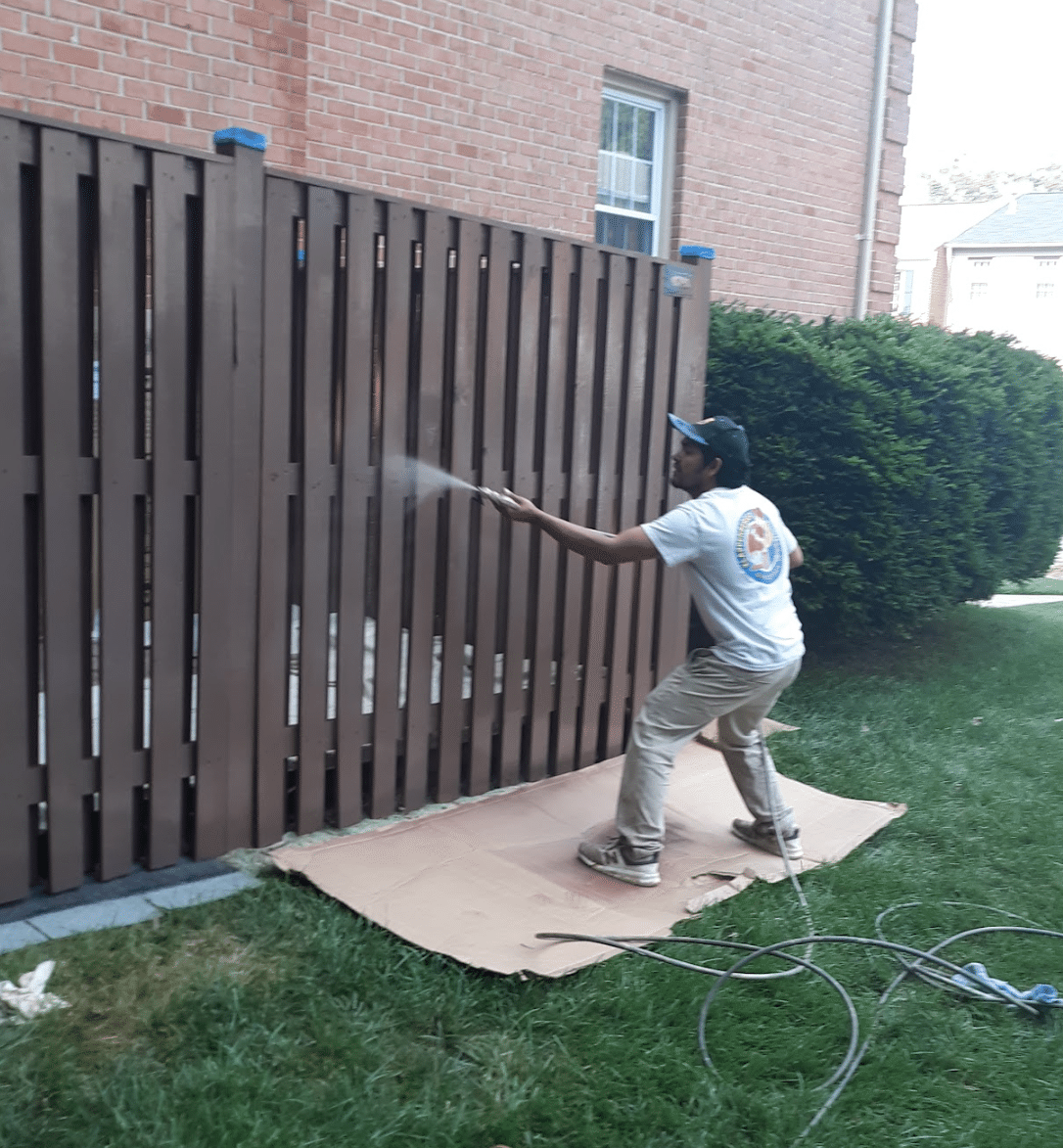 A Painting Company in Nashville spraying a fence