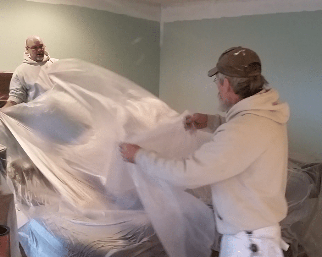 interior painting in Frederick starts by protecting furniture prior to painting.