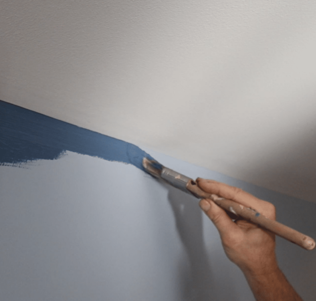 Painting contractor in Fairfax brushing a straight line with blue paint