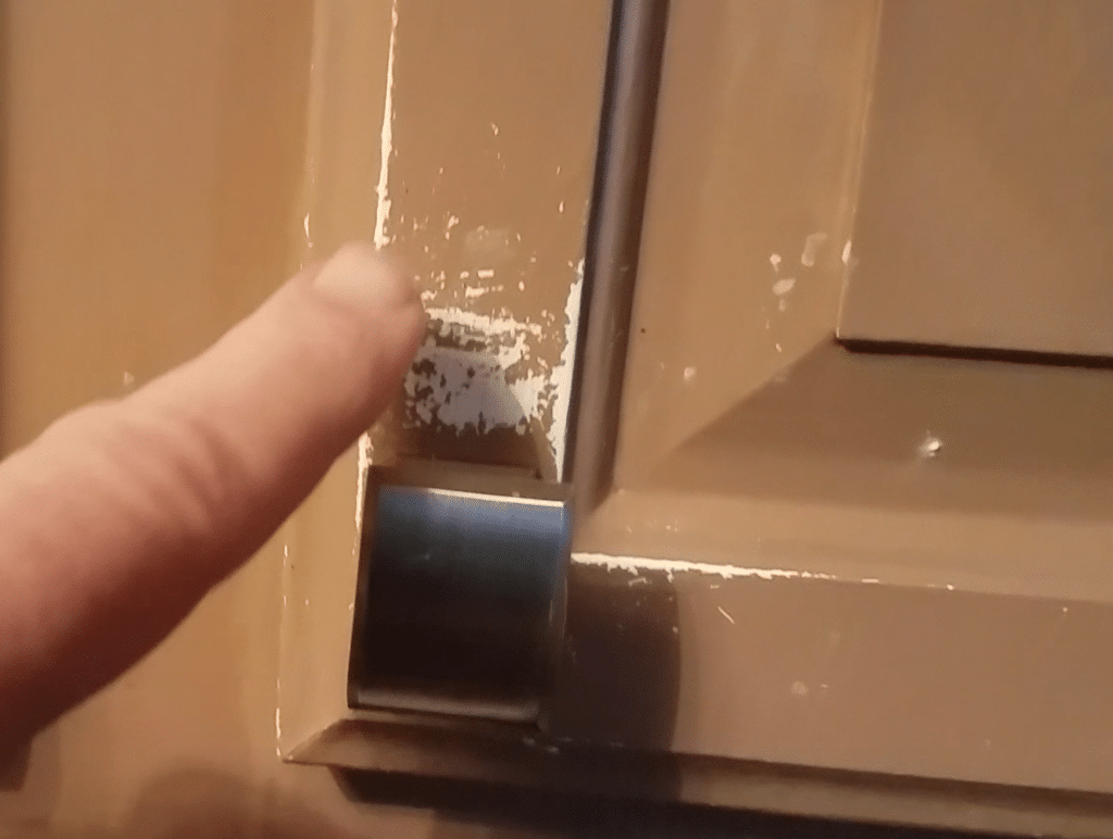 Interior painting company in Columbus, Ohio offers a five-year warranty for scratches on kitchen cabinet. picture shows paint peeling off cabinet.