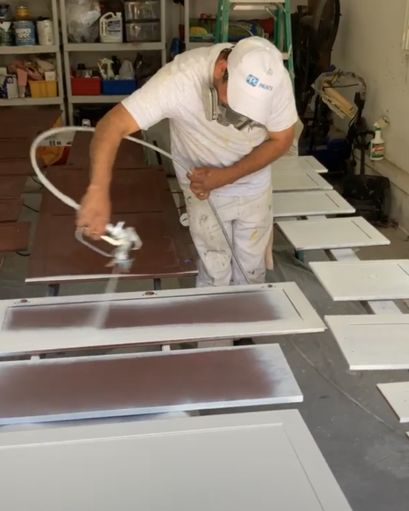 Loudoun county painting contractor, Klappenberger & Son, spraying a primer coat on kitchen cabinet doors.