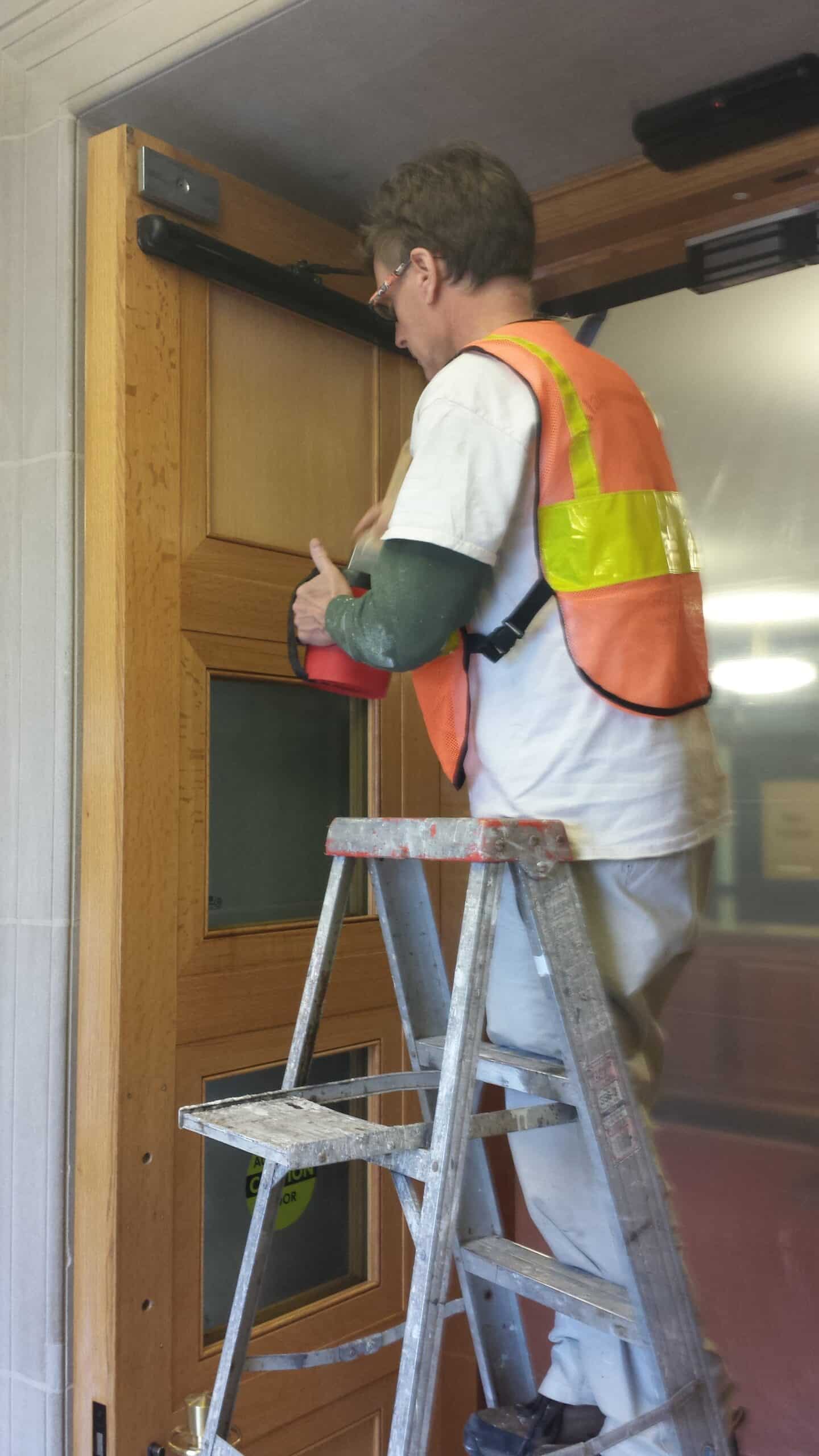 Washington Dc Painter working at Pentagon refinishing doors.