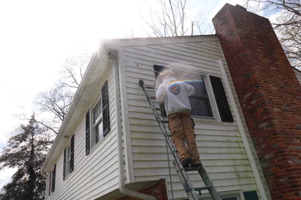 Painter for a day in Baltimore power washing house.