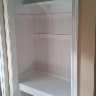 More than crown molding, this closet was custom fitted with a bench and wanescote