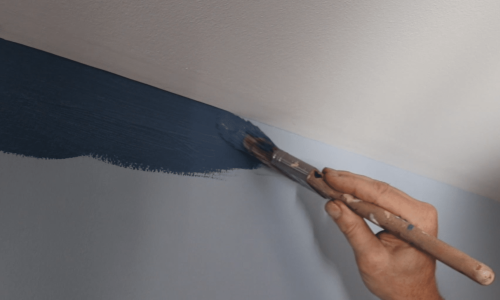 Interior Painting In Washington DC show a real man holding a paintbrush cutting in a straight line.